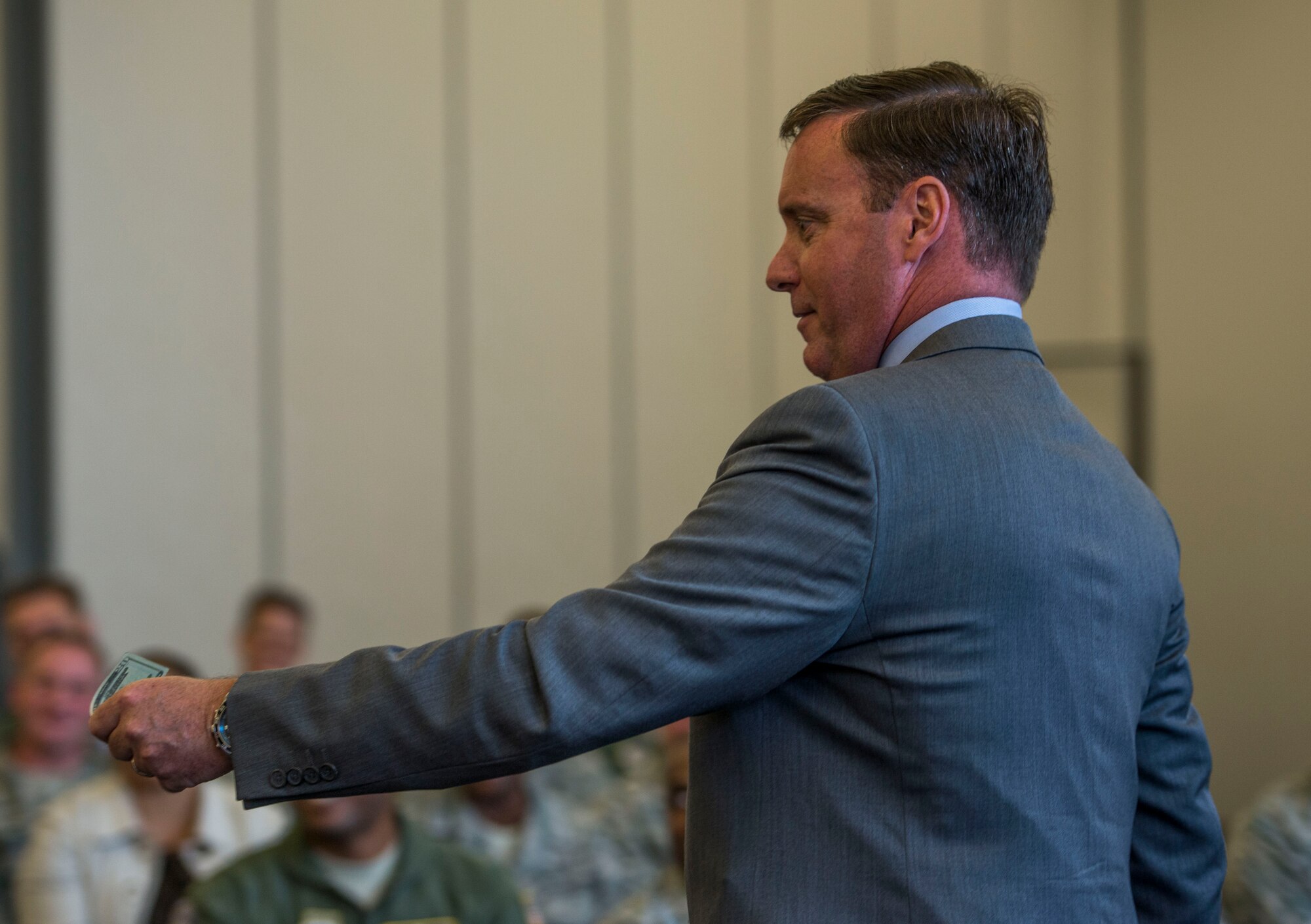 Retired Col. Chuck Hodges, Hiring Our Heroes senior director of events and programs, kicks off the six person panel discussion by offering $20 to the first person who asks a question during a two-day transition summit and hiring and education fair for transitioning members, veterans, and spouses, Scott Air Force Base, Ill., July 12, 2016.  The first day of the transition summit offered industry briefs from Microsoft, the 375th Communications Group, Alcoa, Fastport, and SSM Health to transitioning service members, veterans, and military spouses, followed by a panel discussion with senior leaders of potential employers that answered questions of audience members on the transitioning process. The second day featured employment workshops, another panel discussion on different transition perspectives, and a hiring and education fair.   (U.S. Air Force photo by Staff Sgt. Jodi Martinez/Released)
