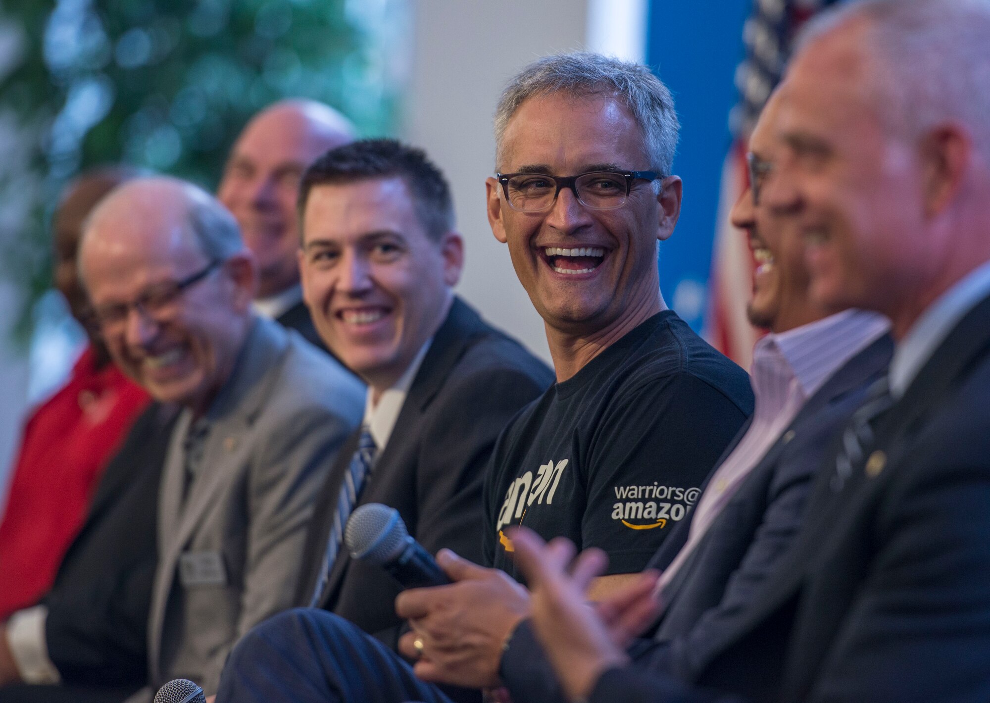 Members of the seven-person panel discussion laugh during a two-day transition summit and hiring and education fair for transitioning members, veterans, and spouses, Scott Air Force Base, Ill., July 12, 2016.  The first day of the transition summit offered industry briefs from Microsoft, the 375th Communications Group, Alcoa, Fastport, and SSM Health to transitioning service members, veterans, and military spouses, followed by a panel discussion with senior leaders of potential employers that answered questions of audience members on the transitioning process. The second day featured employment workshops, another panel discussion on different transition perspectives, and a hiring and education fair.   (U.S. Air Force photo by Staff Sgt. Jodi Martinez/Released)