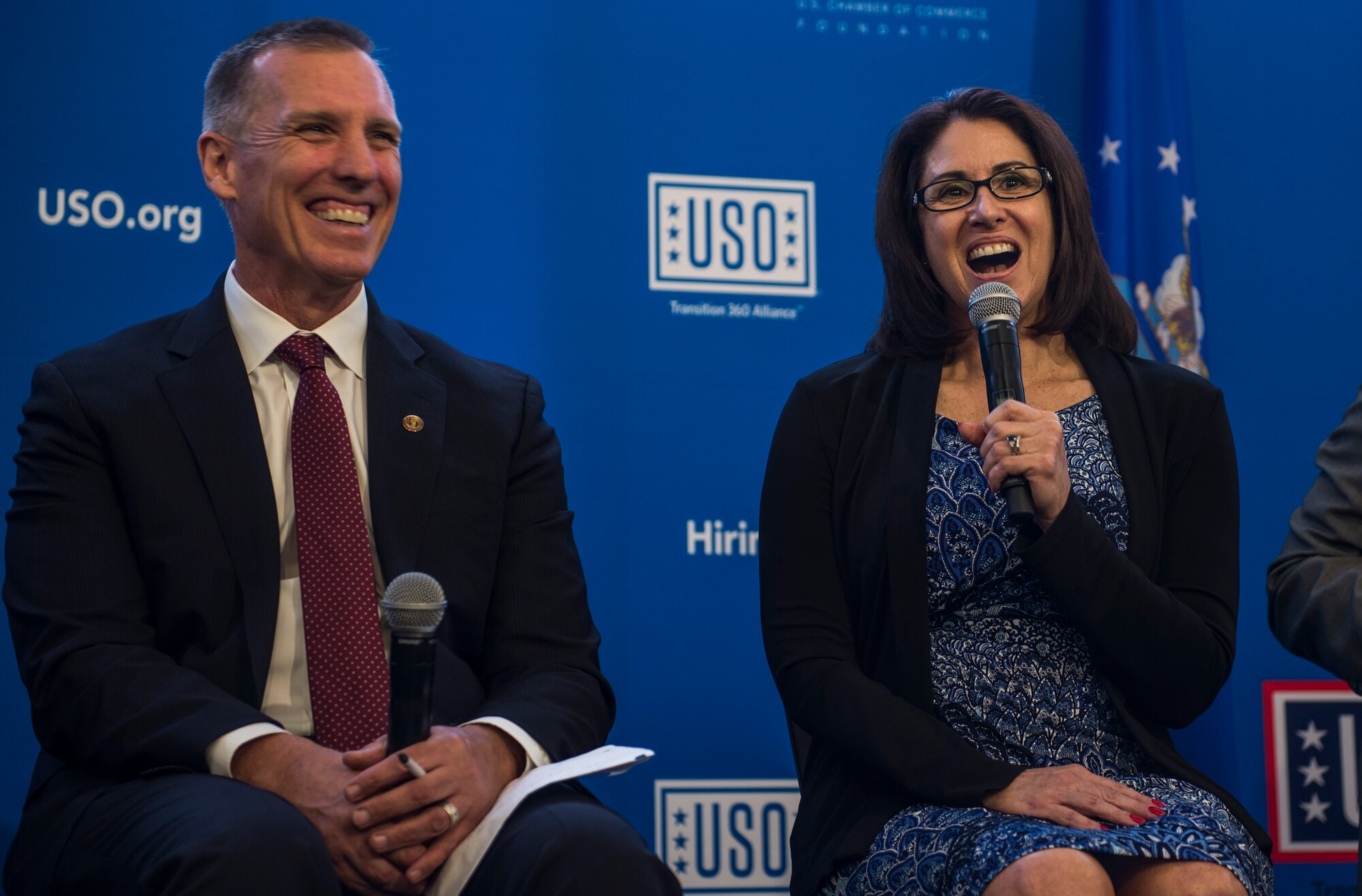 Mark Toal, National Veterans' Employment manager, and Corliss De La Garza, a vocational rehabilitation and employment officer, laugh during a six person panel discussion while answering a question during a two-day transition summit and hiring and education fair for transitioning members, veterans, and spouses, Scott Air Force Base, Ill., July 12, 2016.  The first day of the transition summit offered industry briefs from Microsoft, the 375th Communications Group, Alcoa, Fastport, and SSM Health to transitioning service members, veterans, and military spouses, followed by a panel discussion with senior leaders of potential employers that answered questions of audience members on the transitioning process. The second day featured employment workshops, another panel discussion on different transition perspectives, and a hiring and education fair.   (U.S. Air Force photo by Staff Sgt. Jodi Martinez/Released)