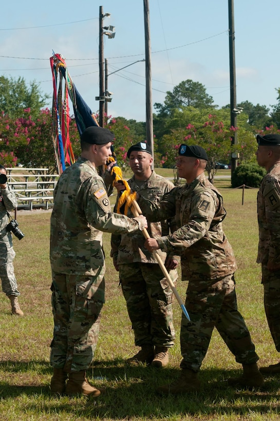 Lt. Col. Christopher W. Warner, outgoing commander of the 2nd Battalion, 345th Regiment, receives the battalion guidon from Command Sgt. Maj. Michael Mew, the outgoing CSM of the 2/345th. Warner has relinquished command to Lt. Col. Augusto Villalaz during a ceremony at Fort Jackson, S.C. July 17. (US Army photo by Sgt. Darryl L. Montgomery, 319th Mobile Public Affairs Detachment)