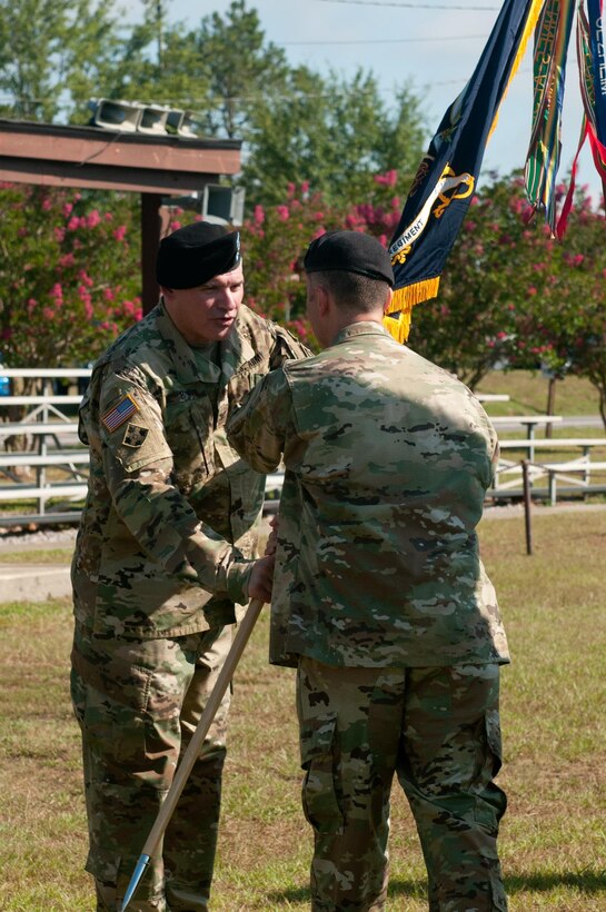 FORT JACKSON, SC – Lt. Col. Christopher W. Warner, outgoing commander of the 2nd Battalion, 345th Regiment, passes the battalion guidon to Col. Matthew H. Fath, the 345th Regiment commander. Warner has relinquished command to Lt. Col. Augusto Villalaz during a ceremony at Fort Jackson, S.C. (US Army photo by Sgt. Darryl L. Montgomery, 319th Mobile Public Affairs Detachment)