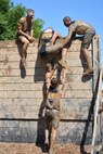 HUGO, Minn. -- Army Reserve Soldiers from the 103rd Sustainment Command (Expeditionary) help each other over the nine foot “Berlin Wall” during the Tough Mudder held in Hugo, Minnesota, July 17, 2016.  The Army Reserve-sponsored, 10 to 12 mile military-style obstacle course has challenged more than one million competitors since its inception in 2010, testing the participants’ strength and stamina while building camaraderie.