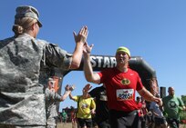 HUGO, Minn.-- Spc. Kimberly Anderson, a Soldier assigned to the 847th Human Resource Company, Fort Snelling, Minnesota, encourages competitors as they embark on the 2016 Twin Cities Tough Mudder in Hugo, Minnesota, July 16. Army Reserve Soldiers from local units provide support for the two-day event. Anderson, a native of Holmen, Wisconsin, says Tough Mudder combines two things she values - community engagement and physical fitness.  (U.S. Army photo by Spc. Claudia Rocha)
