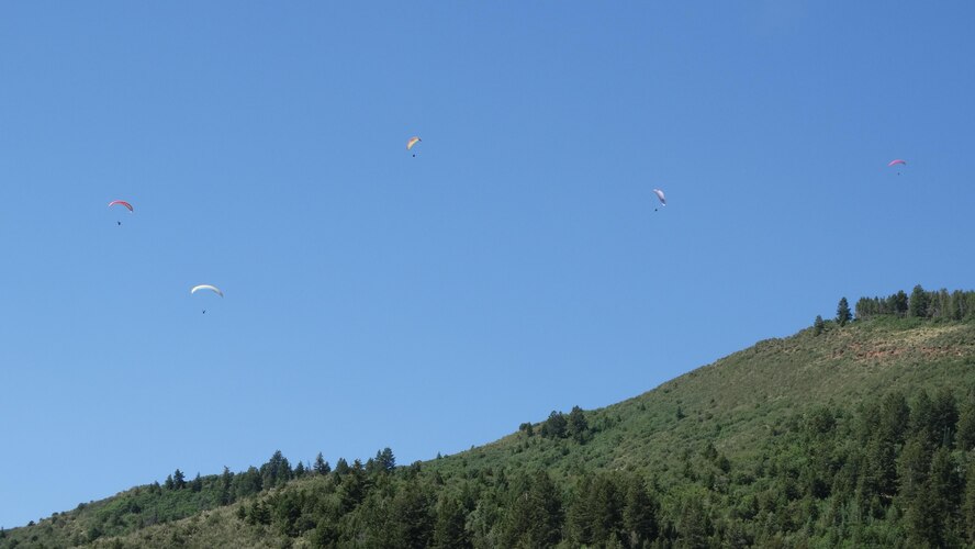 Airmen participating in the Single Airman Initiative paraglide over Vail Valley, Colorado, Saturday, July 16, 2016. With a paraglider, you actually fly like a bird, soaring upwards on currents of air. Paraglider pilots routinely stay aloft for three hours or more, climb to elevations of 15,000 feet and go cross-country for vast distances. (Courtesy Photo)