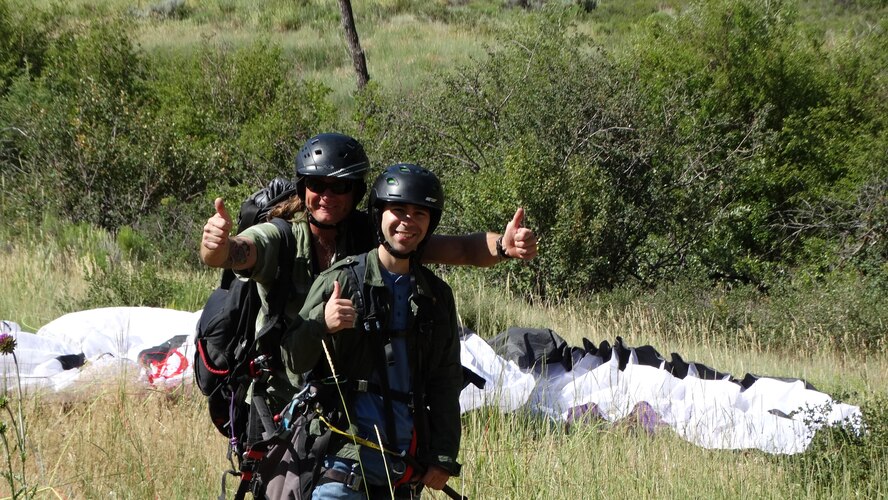 Airman 1st Class Cole Mirek, 4th Space Operations Squadron communication support/terminal operator, celebrates a successful landing with his instructor after soaring in a paraglider over Vail Valley, Colorado, during a Single Airman Initiative event, Saturday, July 16, 2016. The program is open to any Air Force active-duty or Air Reserve Component member, enlisted or officer, who is single, including geographically separated Airmen. (Courtesy Photo)