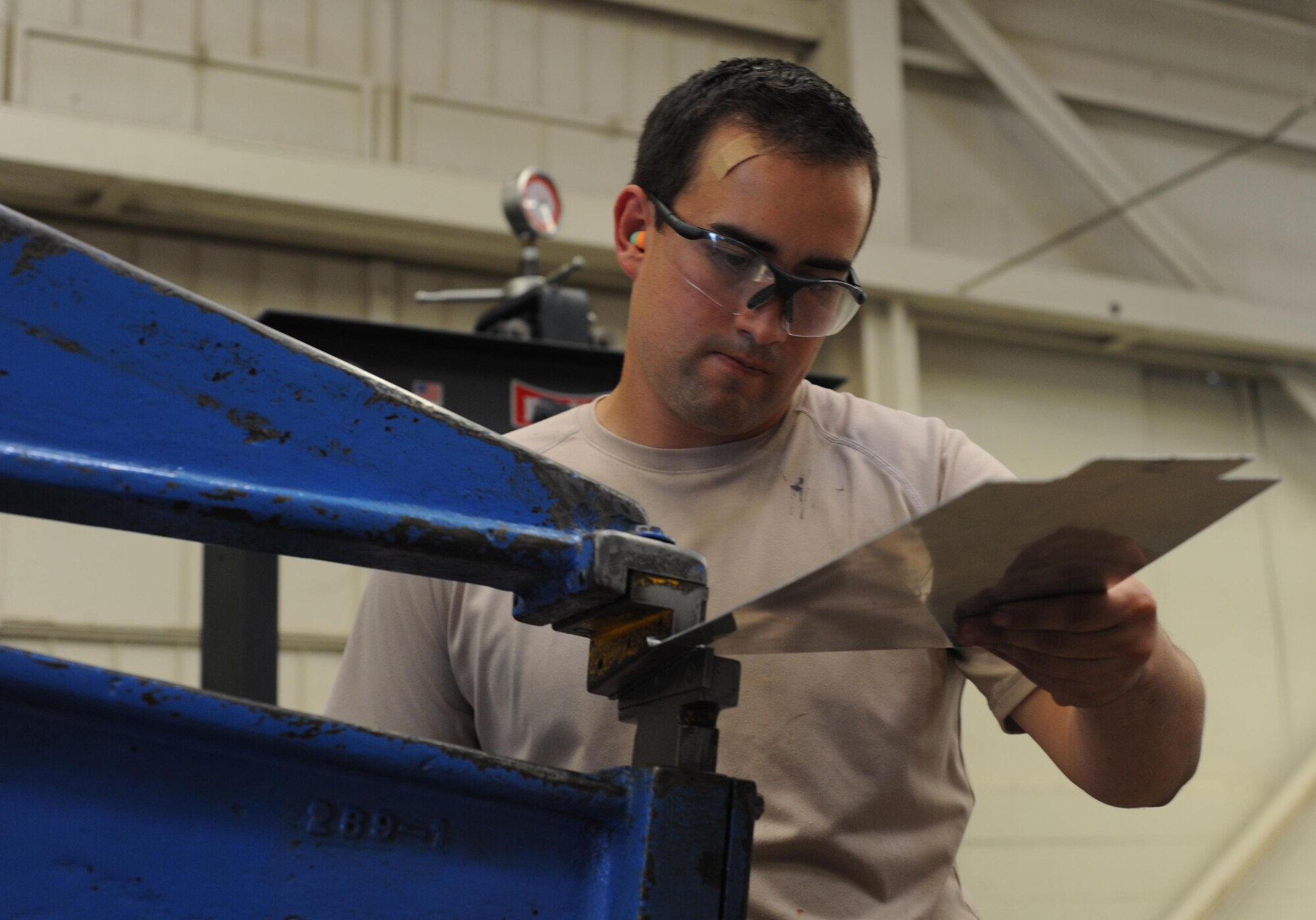 U.S. Air Force Airman 1st Class Christopher Briggs, 7th Equipment Maintenance Squadron aircraft structural apprentice, shapes a sheet of metal July 7, 2016, at Dyess Air Force Base, Texas. In the sheet metal shop, there are more than 38 machines used to either cut, trim, bend, notch, polish or form a variety of metal and tubing. (U.S. Air Force photo by Airman 1st Class Rebecca Van Syoc)