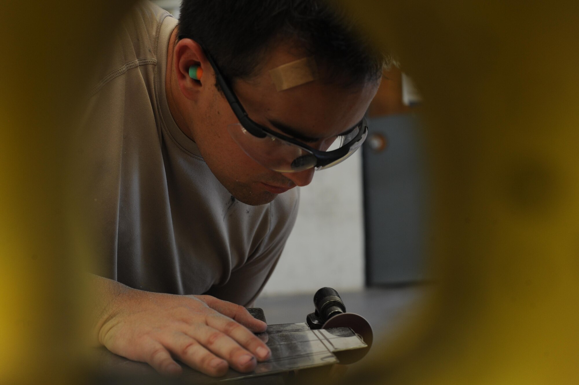 U.S. Air Force Airman 1st Class Christopher Briggs, 7th Equipment Maintenance Squadron aircraft structural apprentice, grinds down a piece of sheet metal July 7, 2016, at Dyess Air Force Base, Texas. Airmen of the sheet metal shop learn to sculpt metal to the exact size or shape needed, down to the millimeter, to ensure repairs of an aircraft are seamless. (U.S. Air Force photo by Airman 1st Class Rebecca Van Syoc)