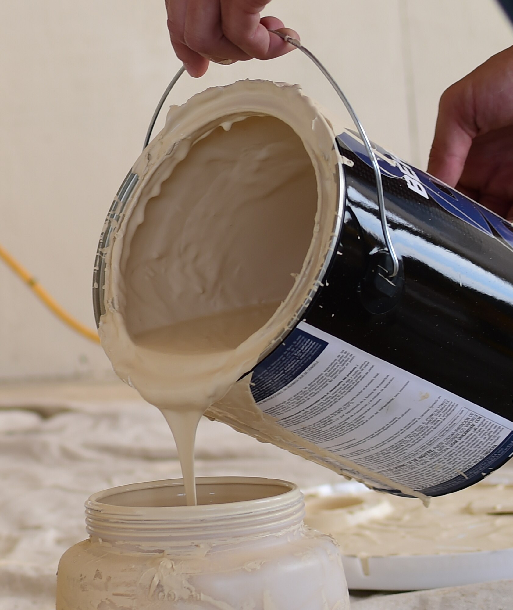 An Airman from the 460th Civil Engineer Squadron pours paint into a container for a paint gun July 18, 2016, on Buckley Air Force Base, Colo. The 460th CES renovated a building on base for Cinderella’s Closet, a place where military members and their dependents can buy gently used formal wear for balls and ceremonies. The 460th CES develops, constructs, operates, and sustains the infrastructure on Buckley AFB. (U.S. Air Force photo by Airman 1st Class Luke W. Nowakowski/Released)