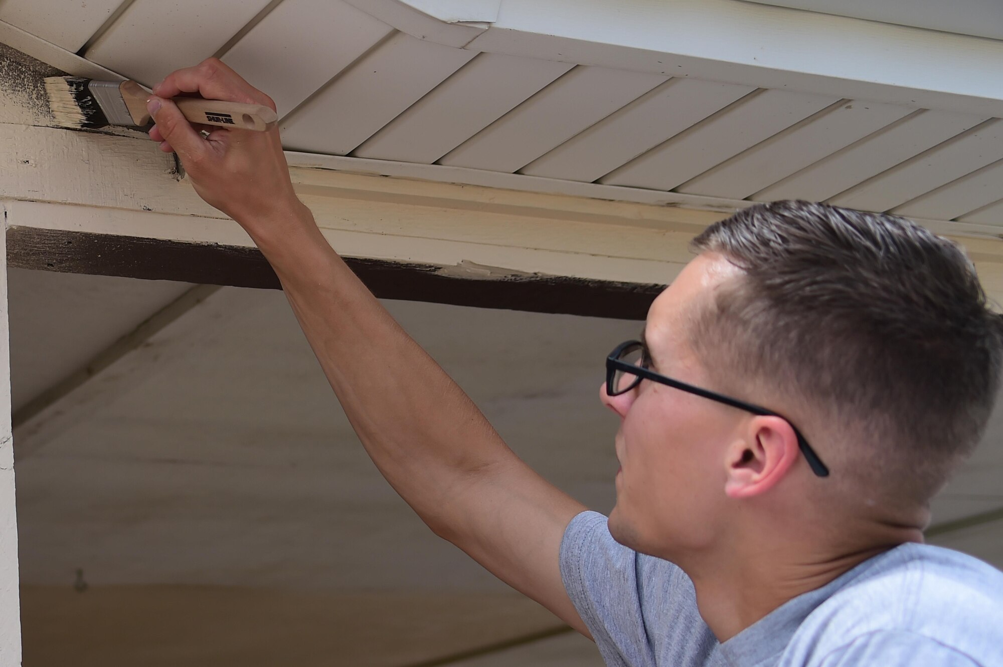Airman 1st Class Kristian Pfennig, 460th Civil Engineer Squadron power production apprentice, paints the outside of a building July 18, 2016, on Buckley Air Force Base, Colo. The 460th CES renovated a building on base for Cinderella’s Closet, a place where military members and their dependents can buy gently used formal wear for balls and ceremonies. The 460th CES develops, constructs, operates, and sustains the infrastructure on Buckley AFB. (U.S. Air Force photo by Airman 1st Class Luke W. Nowakowski/Released)