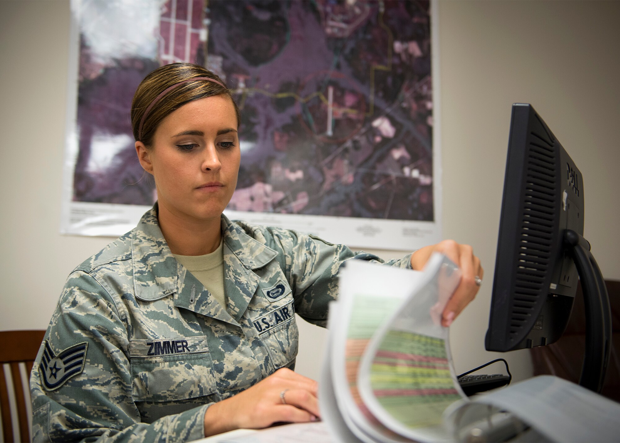 U.S. Air Force Staff Sgt. Jamie Zimmer, 347th Operations Support Squadron intelligence analyst, flips through a binder, June 29, 2016, at Moody Air Force Base, Ga. As an intelligence analyst, Zimmer is responsible for receiving, analyzing, reporting and disseminating information to ensure Airmen remain safe and can successfully complete their missions. (U.S. Air Force photo by Senior Airman Ryan Callaghan)