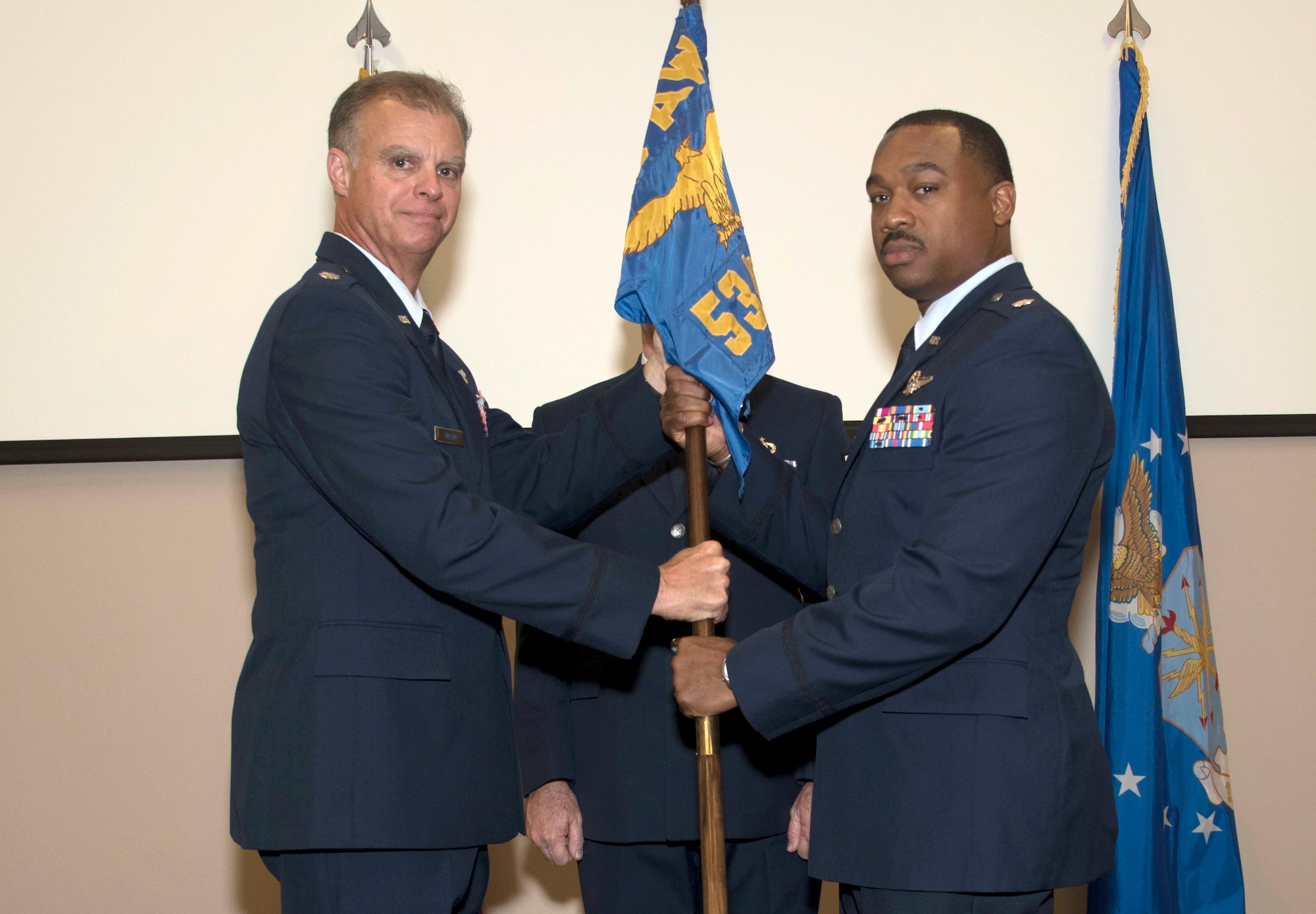 Lt. Col. Keith Gibson, 403rd Operations Group deputy commander, passes the 53rd Weather Reconnaissance Squadron guidon to Lt. Col. Kevin Green, right. Green took command of the 53rd Weather Reconnaissance Squadron during a change of command ceremony at the 53rd WRS Auditorium, Keesler Air Force Base, Mississippi July 15, 2016. (U.S. Air Force photo/Staff Sgt. Nicholas Monteleone)