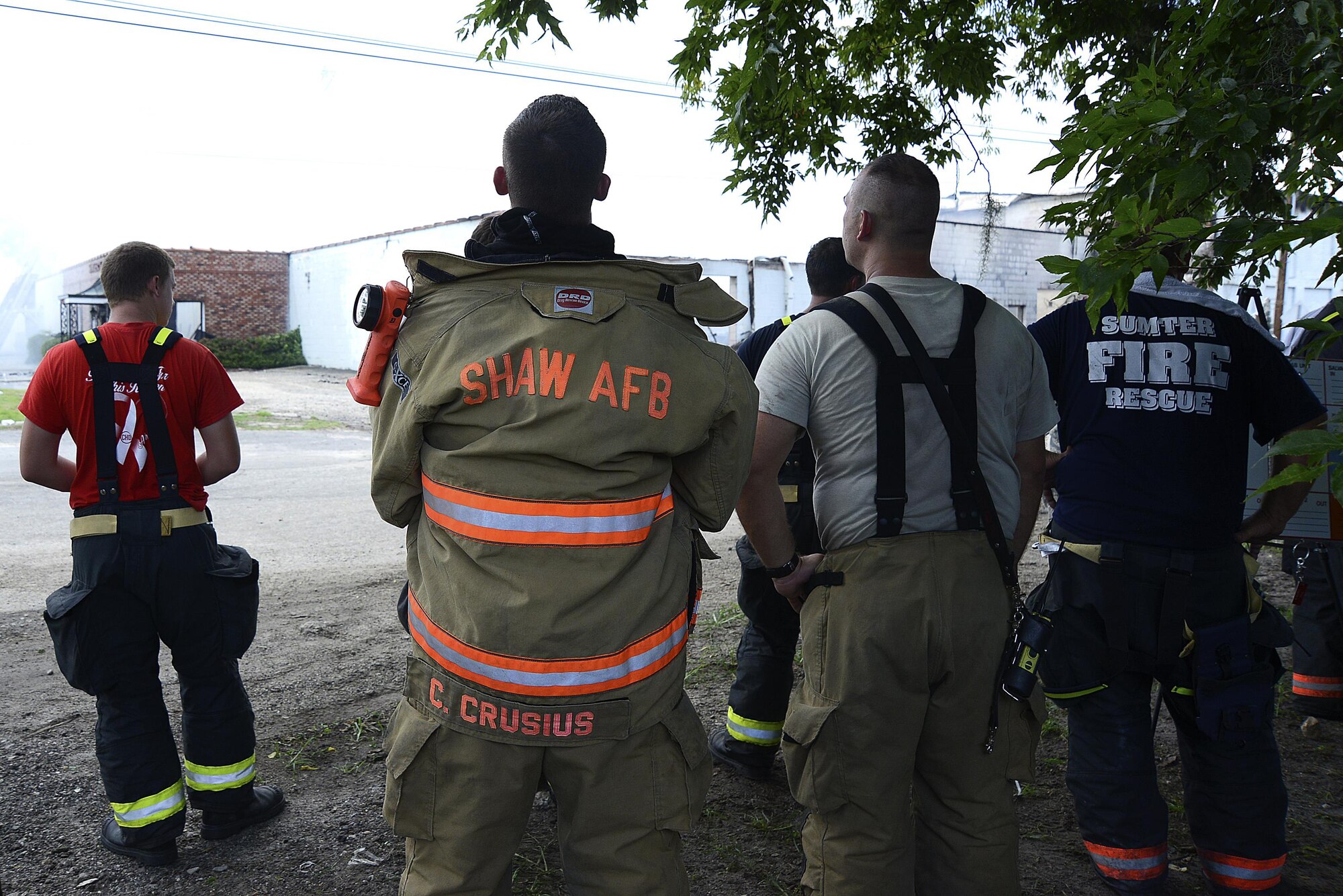 Sumter firemen and 20th Civil Engineer Squadron firemen stand together during a fire response in Sumter S.C., July 18, 2016. Shaw provides Sumter with manpower and equipment while Sumter provides Shaw personnel with more opportunities for real world experiences. (U.S. Air Force photo by Airman BrieAnna Stillman)
