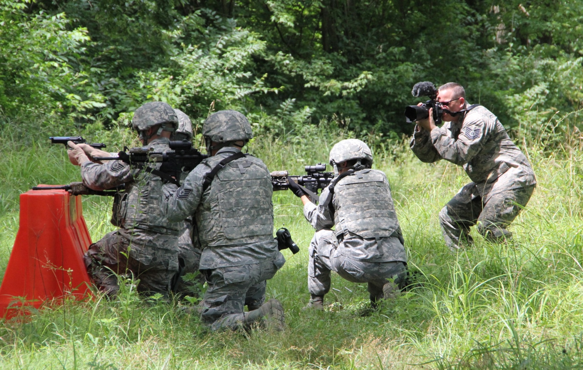 Men and women from the 932nd Airlift Wing Security Forces Squadron took time to load up gear and head to the woods during a busy reserve weekend and train with hand guns and rifles.  Col. Jonathan Philebaum, 932nd AW commander, and Col. Timothy Donnelly, AFRC Deputy Chief of Security Forces Division, Headquarters Air Force Reserve Command, visited the SFS in the field on July 9, 2016, at Scott Air Force Base, Illinois. Donnelly spoke to the Airmen between training to discuss current affairs within Security Forces and address any concerns or questions. The event was documented and covered exclusively by a 932nd AW public affairs duo from multiple angles including this camera at center and at right flank and overhead, carefully shot by Tech. Sgt. Christopher Parr (far right) shooting pictures and video clips.  (U.S. Air Force photo by Maj. Stan Paregien)