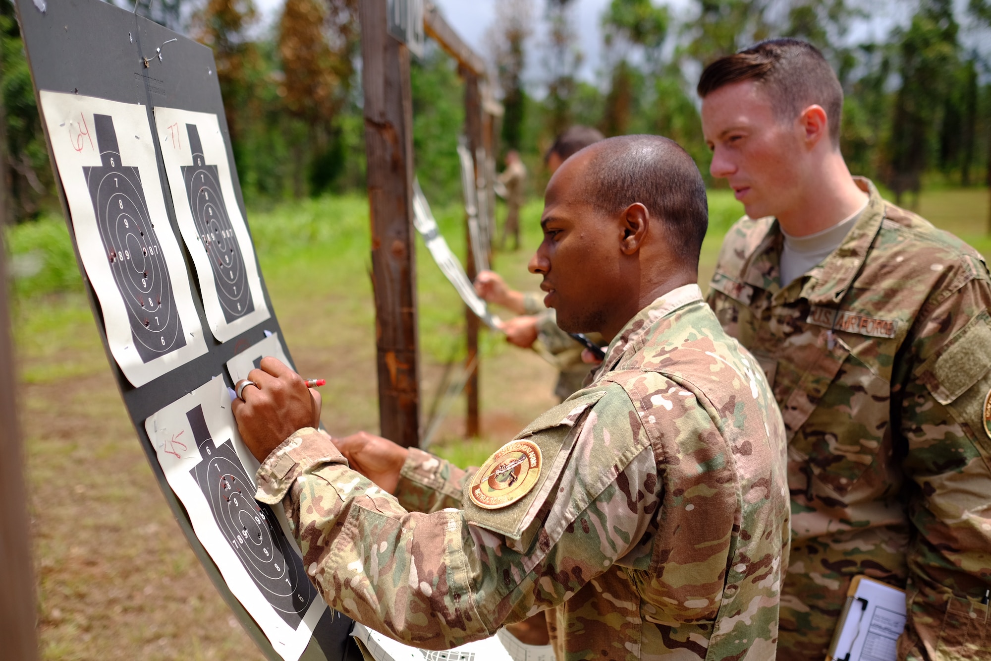 Staff Sgt. Jose Lopez and SSgt. Jordan Locke, 647th Security Forces Squadron Combat Arms Training and Maintenance instructors, tally the score of a participant during the Excellence in Competition M4 event on 15 July at Schofield Barracks, Hawaii. The event, which was held 13-15 July at the 647th SFS Combat Arms Firing Range, allowed would-be marksmen to test their abilities while using the Air Force standard-issue M4 carbine rifle. (U.S Air Force photo by Staff Sgt. Christopher Stoltz)