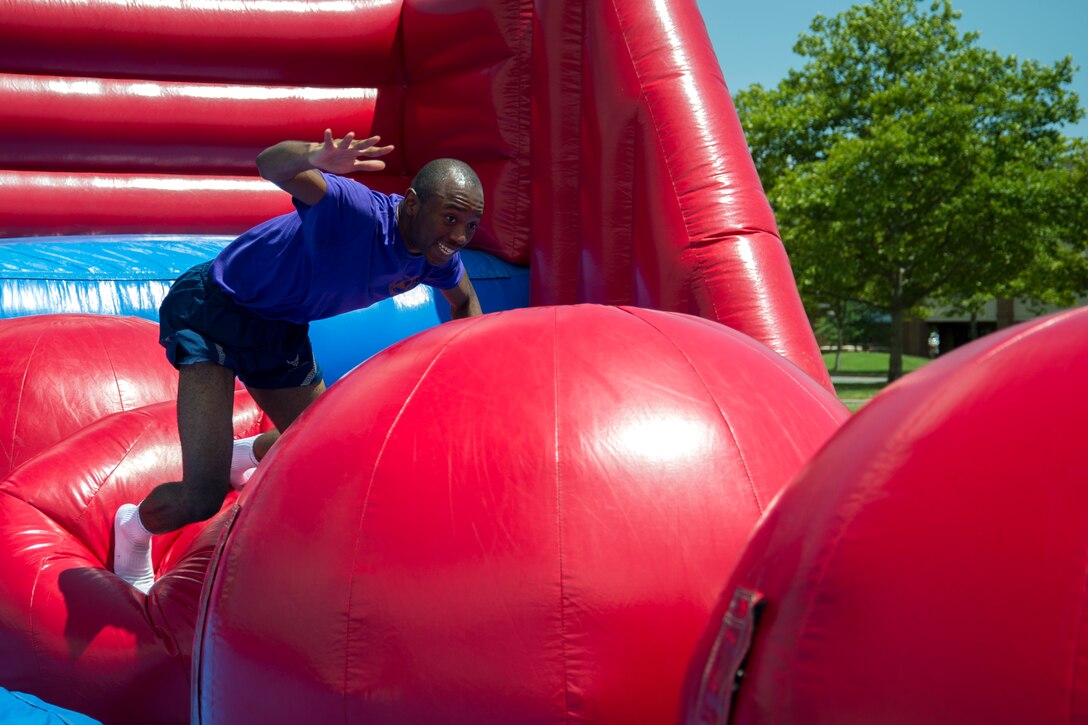 Airman 1st Class Jurah Kromah, 11th Comptroller Squadron financial technician, attempts to make it across “The Big Baller” inflatable obstacle course during the annual dorm challenge event held on Joint Base Andrews, Md., July 15, 2016. The event was hosted by the installation’s Airmen Committed to Excellence club and supported by the USO. Festivities included a disc jockey, free food and drinks, volleyball, cornhole and an array of inflatable obstacles. (U.S. Air Force photo by Airman Gabrielle Spalding)