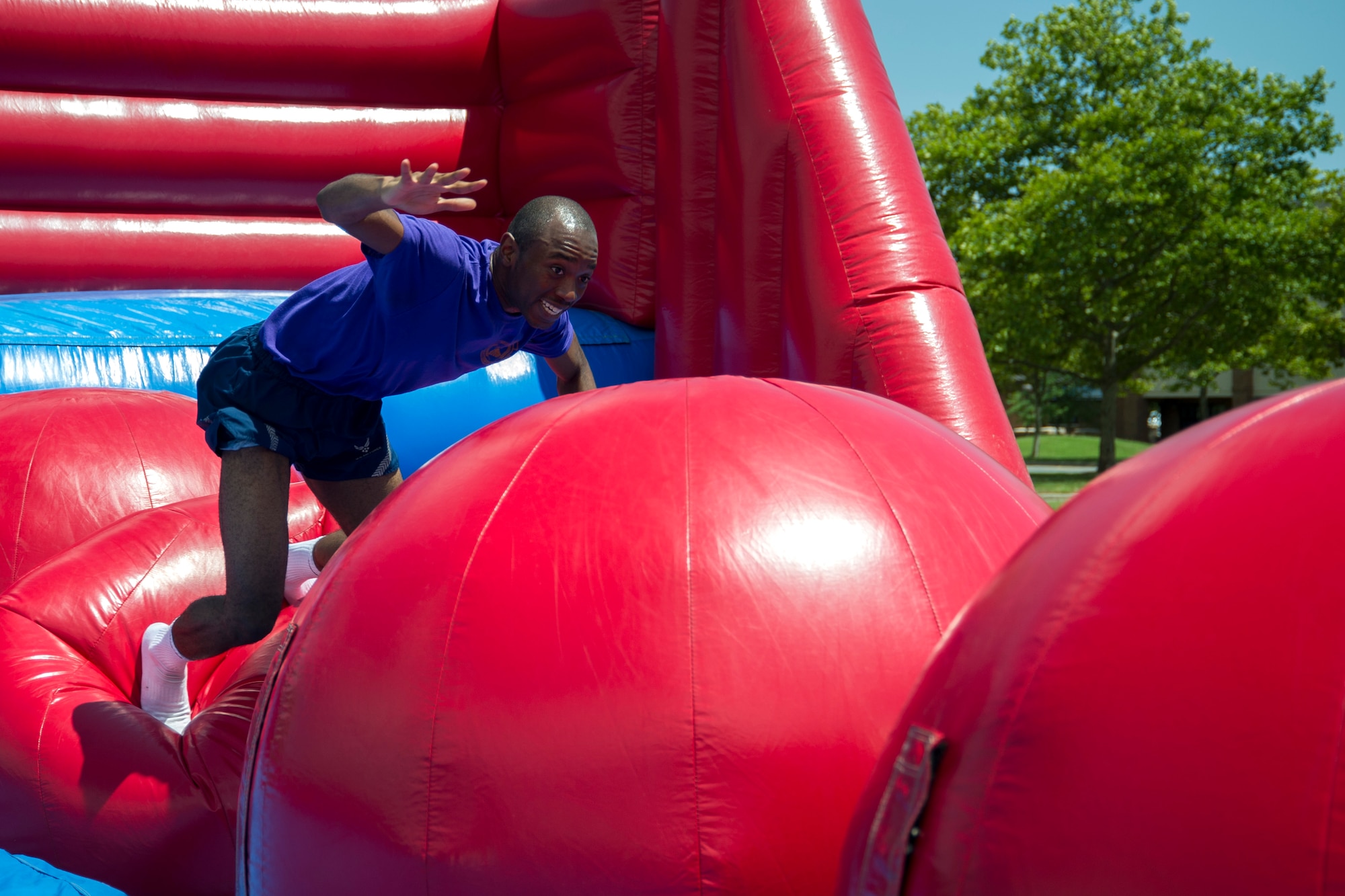 Airman 1st Class Jurah Kromah, 11th Comptroller Squadron financial technician, attempts to make it across “The Big Baller” inflatable obstacle course during the annual dorm challenge event held on Joint Base Andrews, Md., July 15, 2016. The event was hosted by the installation’s Airmen Committed to Excellence club and supported by the USO. Festivities included a disc jockey, free food and drinks, volleyball, cornhole and an array of inflatable obstacles. (U.S. Air Force photo by Airman Gabrielle Spalding)