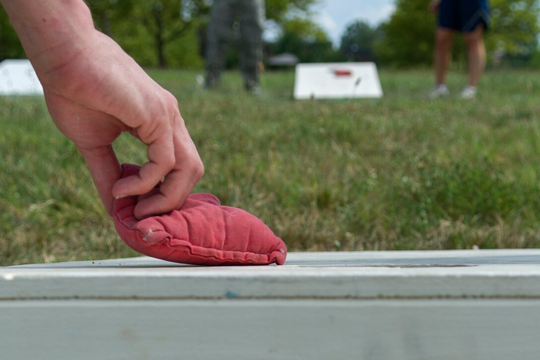 Members of Joint Base Andrews participate in a game of cornhole during the annual dorm challenge held on JBA, Md., July 15, 2016. The event was hosted by the installation’s Airmen Committed to Excellence club and supported by the USO. Festivities included a disc jockey, free food and drinks, volleyball, cornhole and an array of inflatable obstacles. (U.S. Air Force photo by Airman Gabrielle Spalding)