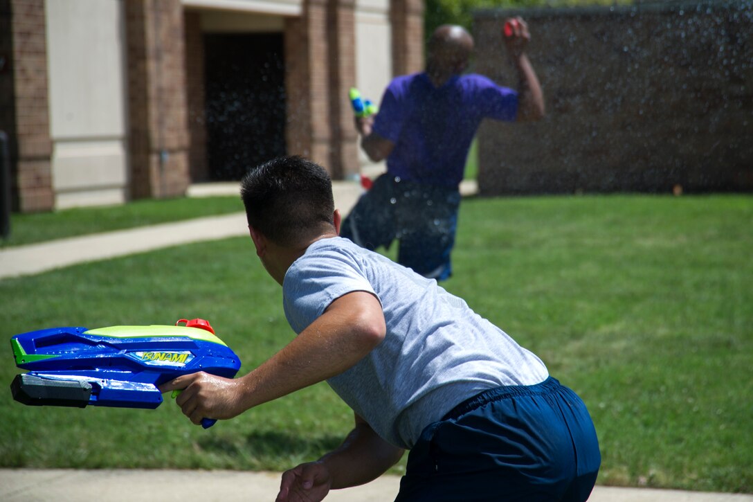 Airman 1st Class Charles Jefferson, 11th Logistics and Readiness Squadron vehicle operator, and Airman 1st Class William Gordon, 11th Comptroller Squadron customer service technician, participate in a water balloon fight during the annual dorm challenge held on Joint Base Andrews, Md., July 15, 2016. The event was hosted by the installation’s Airmen Committed to Excellence club and supported by the USO. Festivities included a disc jockey, free food and drinks, volleyball, cornhole and an array of inflatable obstacles. (U.S. Air Force photo by Airman Gabrielle Spalding)
