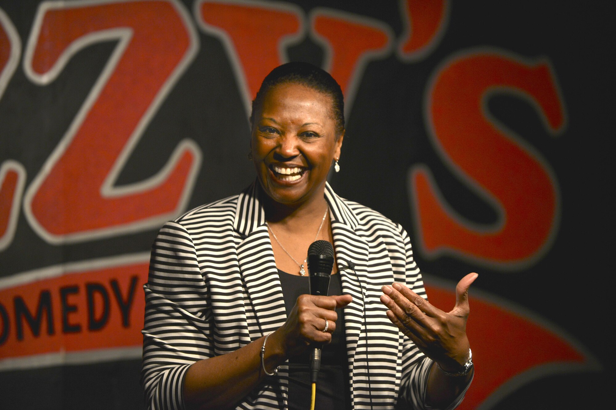 Retired U.S. Air Force Maj. Darlean Basuedayva, U.S. Army Public Health Center and special staff to the Senior Commander Army Element, Center for Initial Military Training health promotion officer, performs a comedy routine at a club in Newport News, Va., April 14, 2016. Basuedayva’s performance was a part of the Armed Services Arts Partnership, which provides military service members and veterans the opportunity to learn artistic skills from artists, art organizations and art students. (U.S. Air Force photo by Staff Sgt. Natasha Stannard)