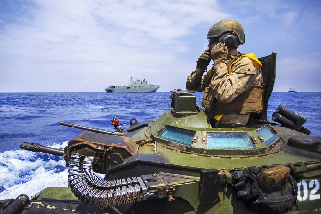 Marine Corps Cpl. Ryan Dills communicates with other assault amphibious vehicles while traveling from amphibious assault ship USS America to the Australian navy amphibious ship HMAS Canberra during Rim of the Pacific 2016 in the Pacific Ocean, July 18, 2016. Dills is a vehicle commander assigned to Combat Assault Company, 3rd Marine Regiment. Marine Corps photo by Staff Sgt. Christopher Giannetti