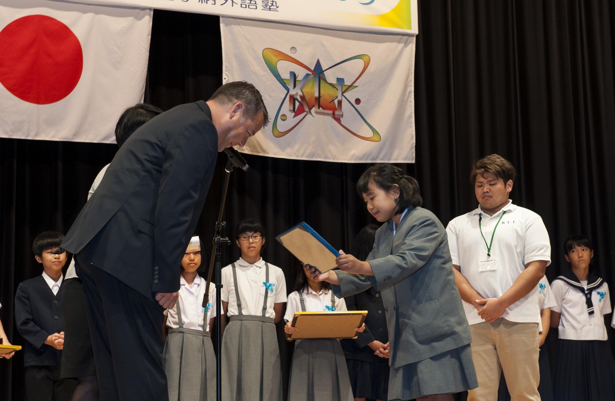Iroha Ganaha, Kadena Elementary School fifth grade student, receives the 18th Wing Special Award from U.S. Air Force Col. Paul Oldham, 18th Mission Support Group commander, during the 19th annual Kadena Language Institute English Contest July 14, 2016, at the Kadena Rotary Town Plaza, Okinawa, Japan. The 18th Wing Special Award winner is hand-chosen by the 18th MSG commander based on their performance. (U.S. Air Force photo by Airman 1st Class Lynette M. Rolen)