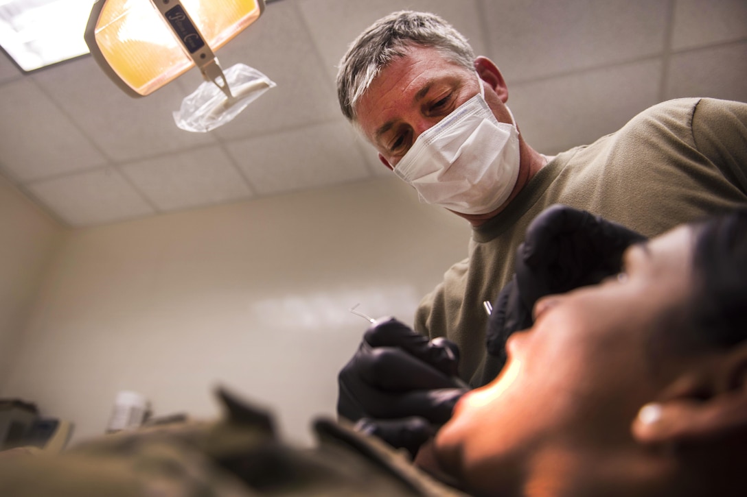 Army Capt. John Mann examines a patient’s teeth at Bagram Airfield in Afghanistan, July 16, 2016. Mann is a dentist assigned to the 129th Area Support Medical Company. The dental clinic at Joint Craig Theater Hospital sees an average of 100 patients a month and performs emergency dental procedures, including root canals and extractions. Air Force photo by Senior Airman Justyn M. Freeman