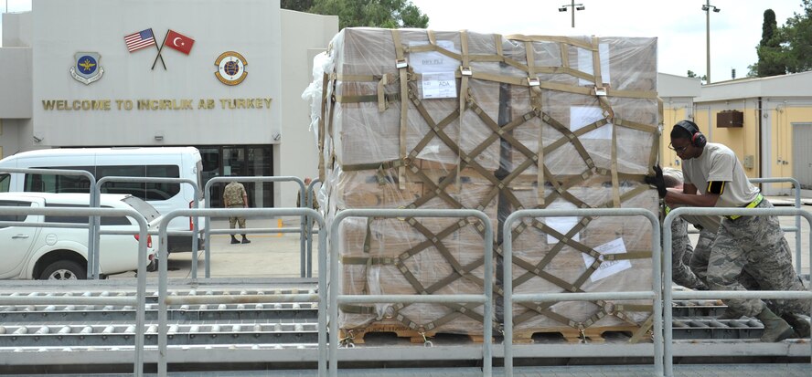 U.S. Airmen from the 728th Air Mobility Squadron push a pallet of meals, ready to eat onto rollers, July 19, 2016, at Incirlik Air Base, Turkey. Due to an extended loss of commercial power, food, fuel and other supplies were sent to Incirlik to sustain missions in support of Operation Inherent Resolve. (U.S. Air Force photo by Tech. Sgt. Joshua T. Jasper)