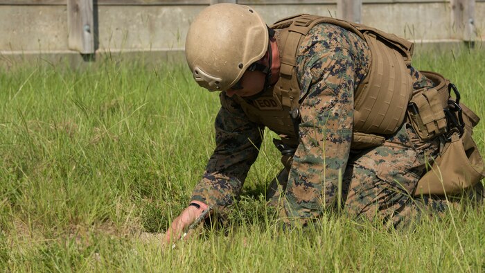 Sgt. David Jones, an explosive ordnance disposal team leader with 2nd EOD Company, 8th Engineer Support Battalion, uncovers part of a controlled improvised explosive device during a training exercise at Marine Corps Base Camp Lejeune, N.C., July 19, 2016. The unit conducted the training to test the effects of different types of excavation charges. 