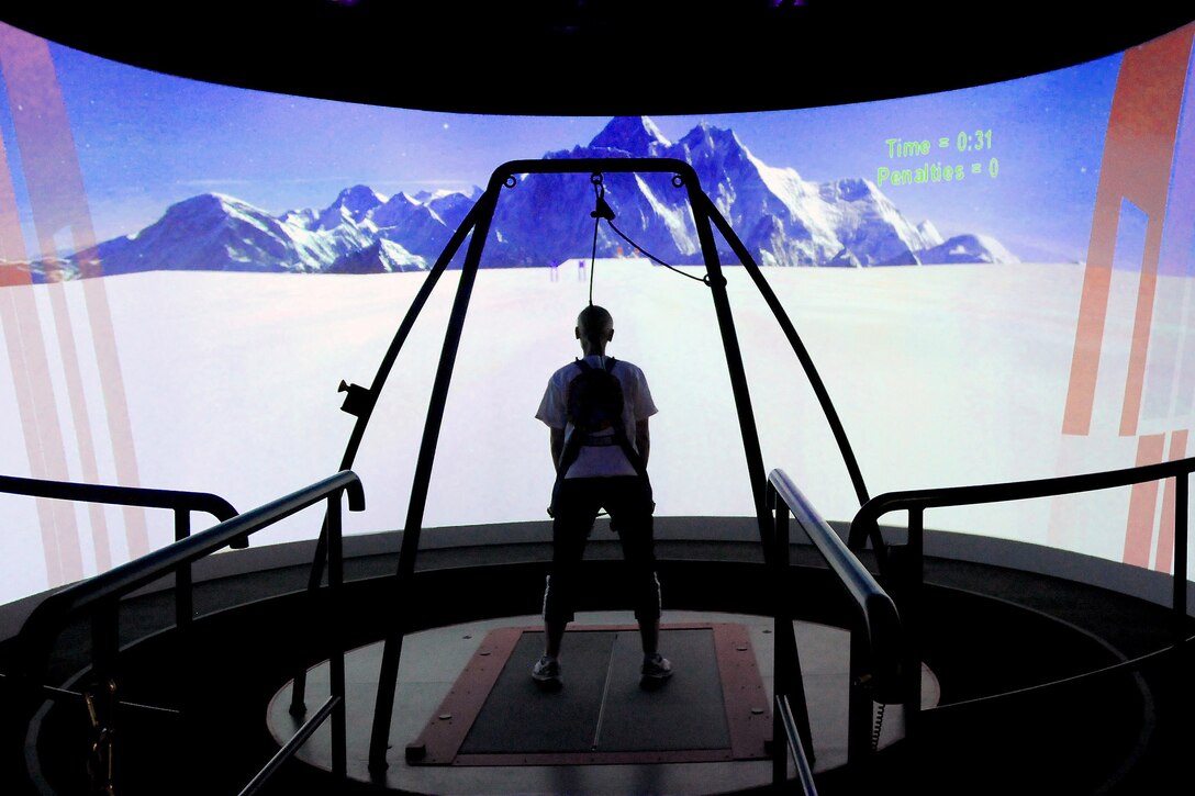 A technician demonstrates how a patient with a traumatic brain injury uses the Computer Assisted Rehabilitation Environment (CAREN) virtual reality to help them with movement and balance at the National Intrepid Center of Excellence in Bethesda, Maryland. (Courtesy photo)