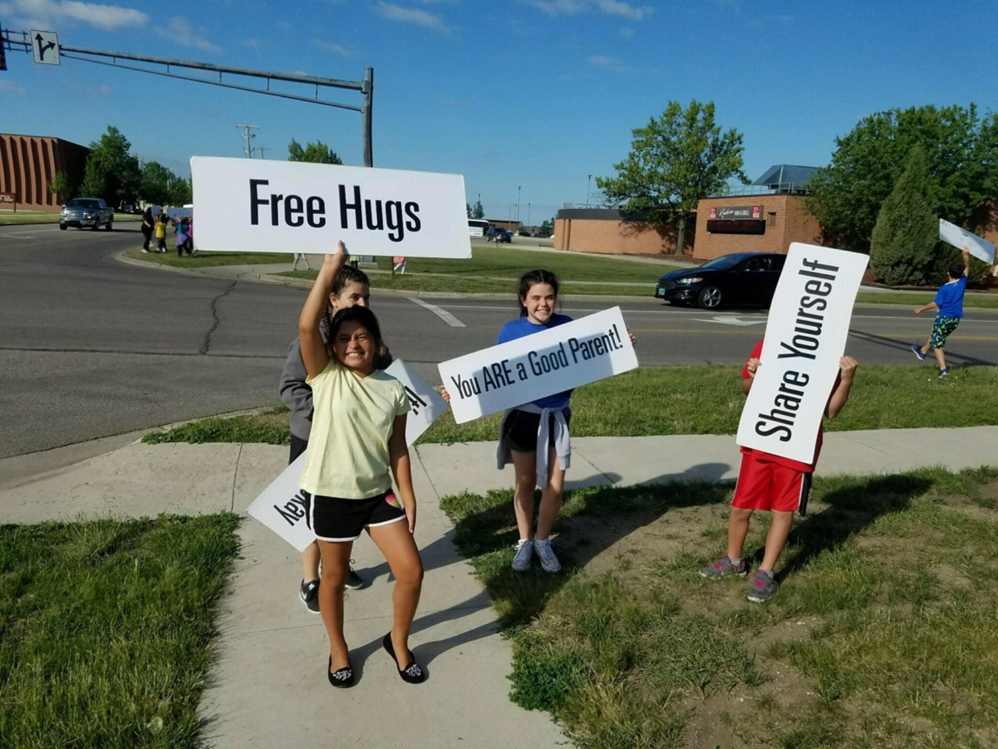 Children from the Youth Center School-Age Program at Minot Air Force Base, N.D., hold up signs with words of encouragement June 28, 2016. Children held up signs as part of the Sprinkling Happiness project. (Courtesy Photo)