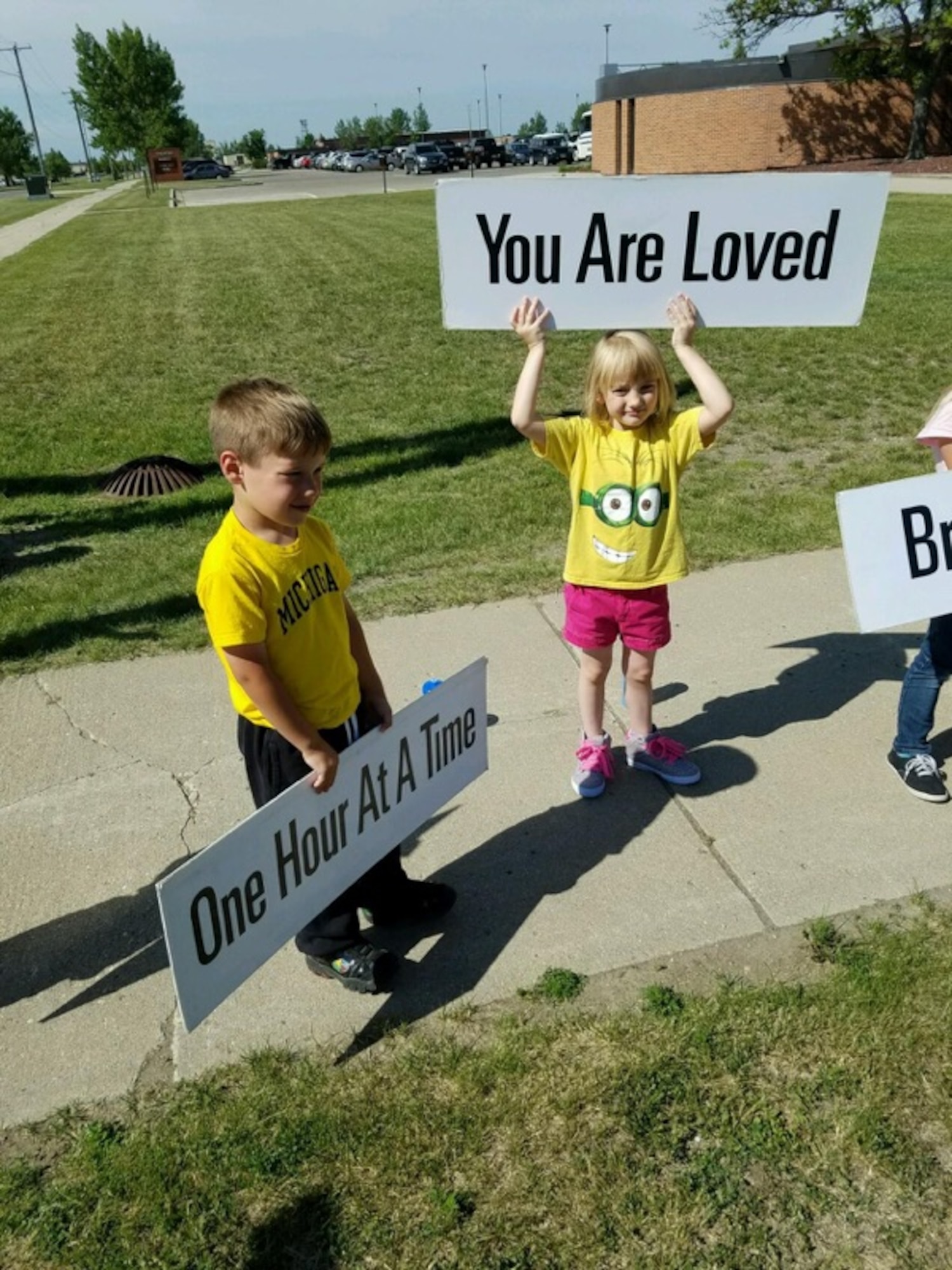 Children from the Youth Center School-Age Program at Minot Air Force Base, N.D., hold up signs with words of encouragement June 28, 2016. Children held up signs as part of the Sprinkling Happiness project. (Courtesy Photo)