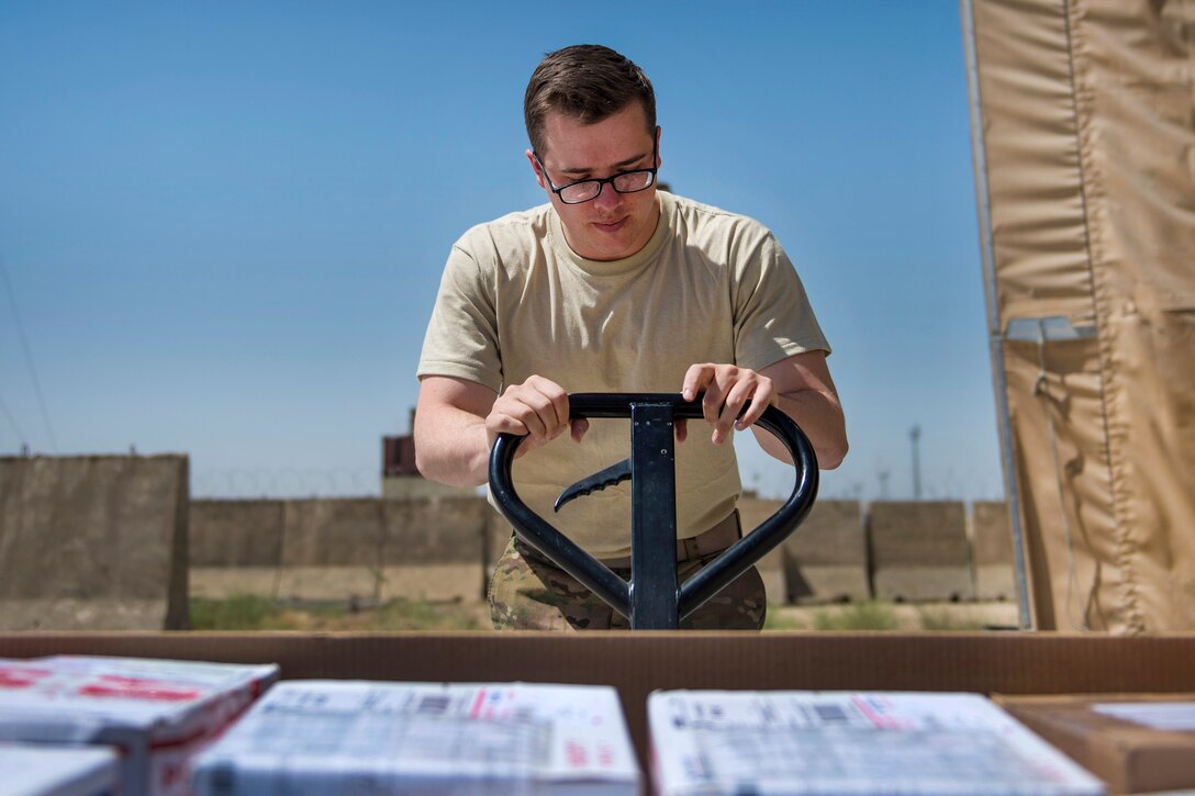 Air Force Senior Airman Christopher Collins uses a floor jack to lift mail at Bagram Airfield in Afghanistan, July 13, 2016. Collins is a knowledge management craftsman assigned to the 455th Expeditionary Communications Squadron. Air Force photo by Senior Airman Justyn M. Freeman