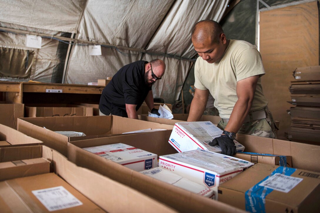 Air Force Staff Sgt. Tony Tran, right, sorts packages at Bagram Airfield in Afghanistan, July 13, 2016. Tran is a knowledge management craftsman assigned to the 455th Expeditionary Communications Squadron. Air Force photo by Senior Airman Justyn M. Freeman