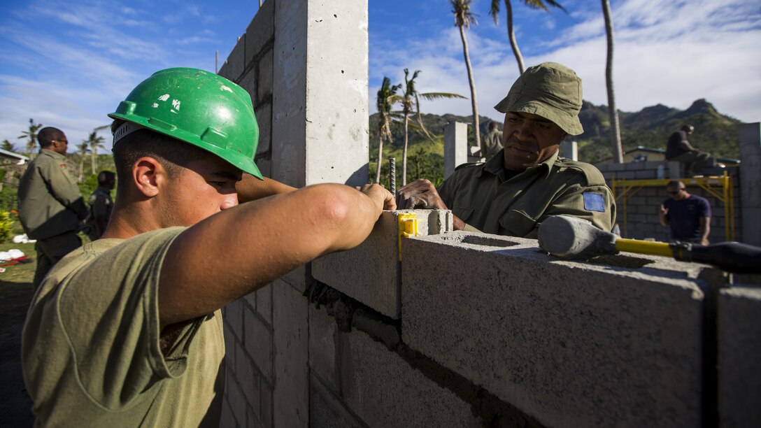 U.S. Marine Cpl. Isaias Pachicano and Republic of Fiji Military Forces Soldier Spr. Tevita Cuvatoka lay down cement blocks during vertical construction training on Ovalau, Fiji, July 20, 2016. Fiji is part of Task Force Koa Moana’s deployment throughout the Asia-Pacific region, where Marines and Sailors will share engineering and infantry skills with the RFMF to strengthen mil-to-mil relationships and interoperability.