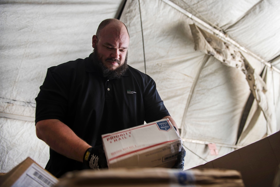 Shaun Cole checks the shipping address on packages at Bagram Airfield in Afghanistan, July 13, 2016. Cole is assigned to the 455th Expeditionary Communications Squadron. Air Force photo by Senior Airman Justyn M. Freeman