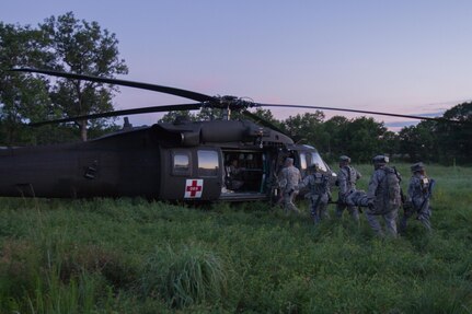 U.S. Army Soldiers under the 330th Medical Brigade practice loading a patient onto a UH-60 Blackhawk assigned to the 2-238th General Support Aviation Battalion, West Bend, Wis. during Warrior Exercise (WAREX) 86-16-03 at Fort McCoy, Wis., July 15, 2016. WAREX is designed to keep soldiers all across the United States ready to deploy. (U.S. Army photo by Spc. Cody Hein/Released)