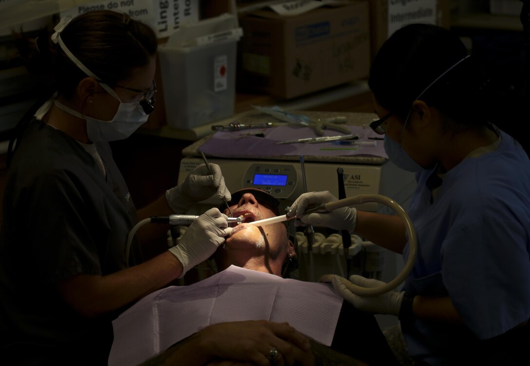 U.S. Air Force Maj. Jessica Bramlette, left, a dentist assigned to the New Jersey Air National Guard's 177th Medical Group, and Spc. Zhuhying Deng, a dental assistant from the U.S. Army Reserve's 7234th Medical Support Unit work on a patient at Homer Intermediate School, Homer, N.Y., July 20, 2016. Service members provided no cost medical, dental, optometry, and veterinary care to local residents as part of the Healthy Cortland 2016 Innovative Readiness Training mission. (U.S. Air National Guard photo by Tech. Sgt. Matt Hecht/Released)