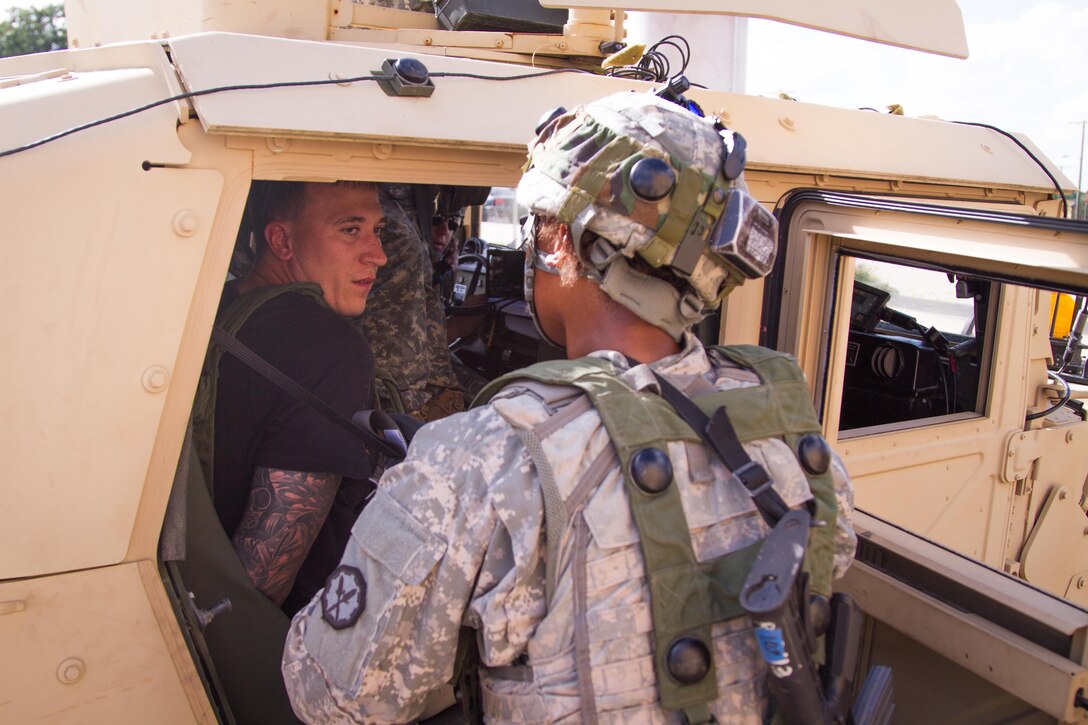 U.S. Army Spc. Andrea Manboard, 304th Military Police Company, 336th Military Police Battalion, 333rd Military Police Brigade, 200th Military Police Command, West Palm Beach, Florida, secures a role player, acting as a high value target, in a vehicle to be escorted to a detainee collection point, where they will be processed prior to arrival at a theater internment facility, during Warrior Exercise (WAREX) 86-16-03 at Fort McCoy, Wis., July 17, 2016. WAREX is designed to keep soldiers all across the United States ready to deploy. (U.S. Army photo by Spc. Cody Hein/Released)