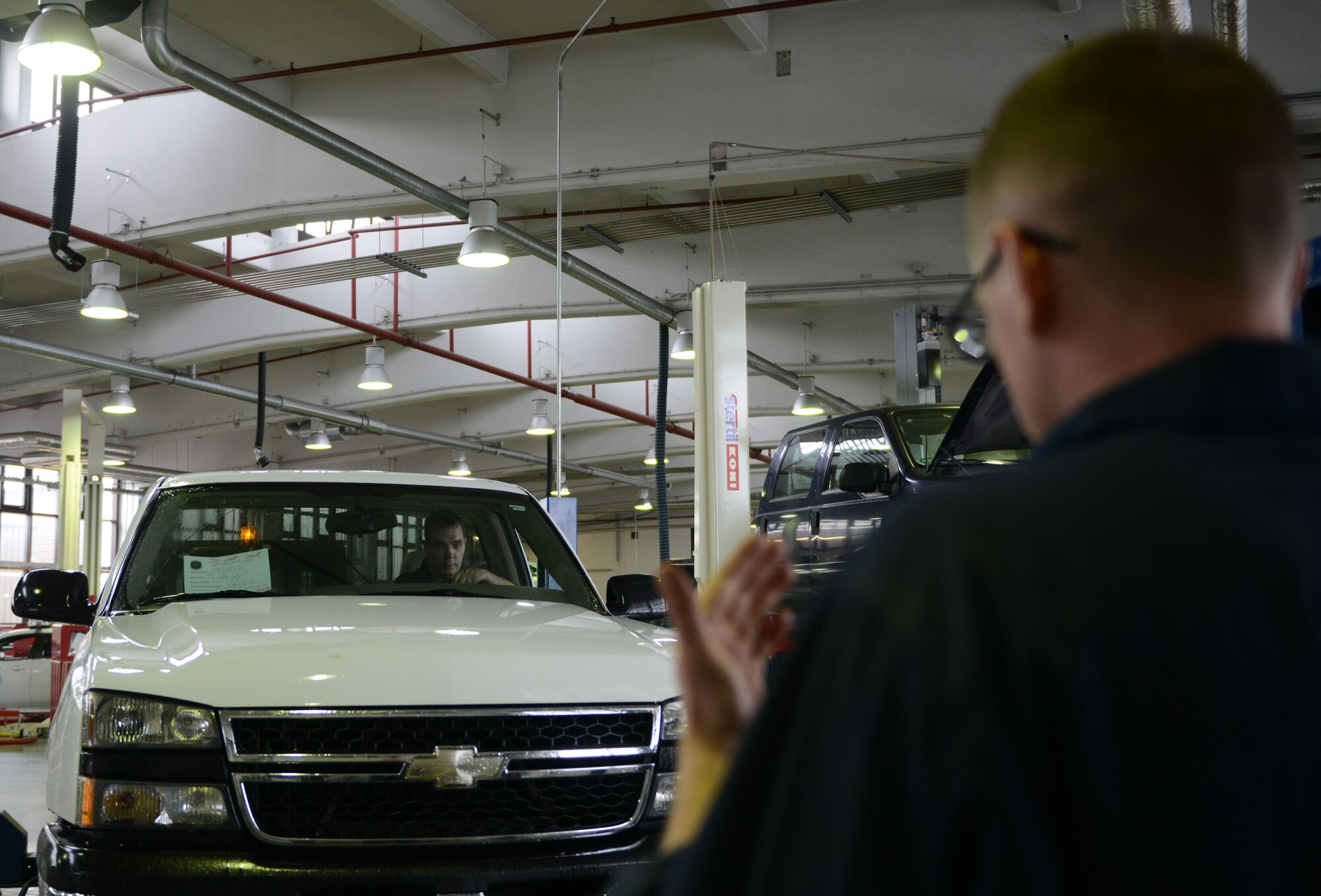 Airman 1st Class Mike Park, 86th Vehicle Readiness Squadron vehicle maintainer, guides a truck to prepare it for maintenance at Ramstein Air Base, Germany, July 13, 2016. Units all around Ramstein send their government-owned vehicles to the 86th VRS for maintenance. (U.S. Air Force photo/ Airman 1st Class Joshua Magbanua)