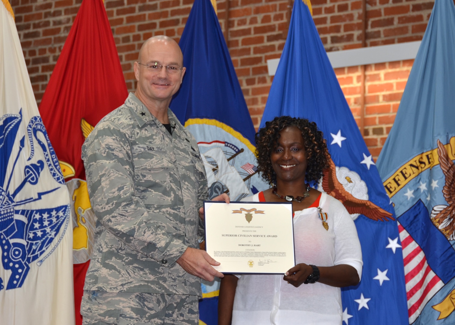 Defense Logistics Agency Aviation Commander Air Force Brig. Gen. Allan Day presents Dorothy Hart, inventory manager, DLA Aviation Business Process Support Directorate with the Superior Civilian Service Award during his town hall held at the Lotts Center on Defense Supply Center Richmond, Virginia, July 15, 2016. 