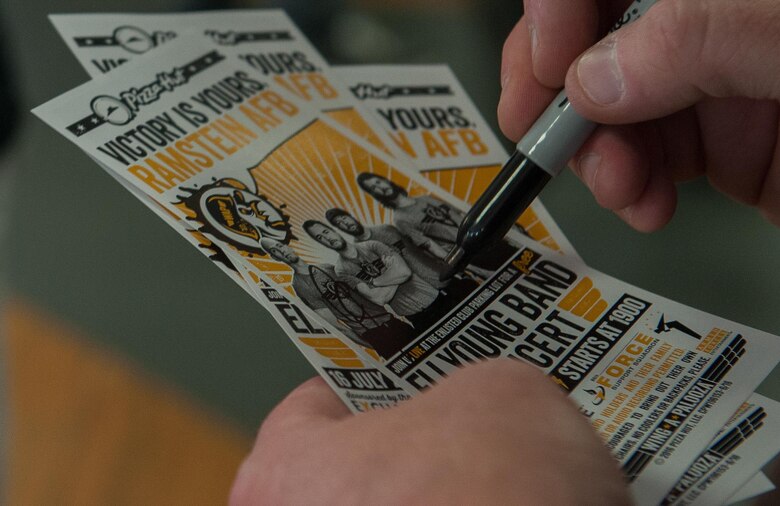 A member of the Eli Young Band signs concert tickets July 15, 2016, at Ramstein Air Base, Germany. The band visited Ramstein after the base’s Pizza Hut won the “Wing-A-Palooza” challenge and served the most wings of any Pizza Hut in Europe. (U.S. Air Force photo/Airman 1st Class Lane T. Plummer)