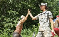 HUGO, Minn. -- Spc. Jamie Walker, an automated logistical specialist with the 322nd Support Maintenance Company, Arden Hills, Minnesota, congratulates participants as they complete the Berlin Wall, one of three obstacles in the 2016 Twin City Tough Mudder provided by the Army Reserve in Hugo, Minnesota, July 16. Army Reserve Soldiers from local units provide support for the two day event. Walker said the participants’ excitement was contagious and hopes to volunteer in future Tough Mudder events. (U.S. Army photo by Spc. Claudia Rocha)