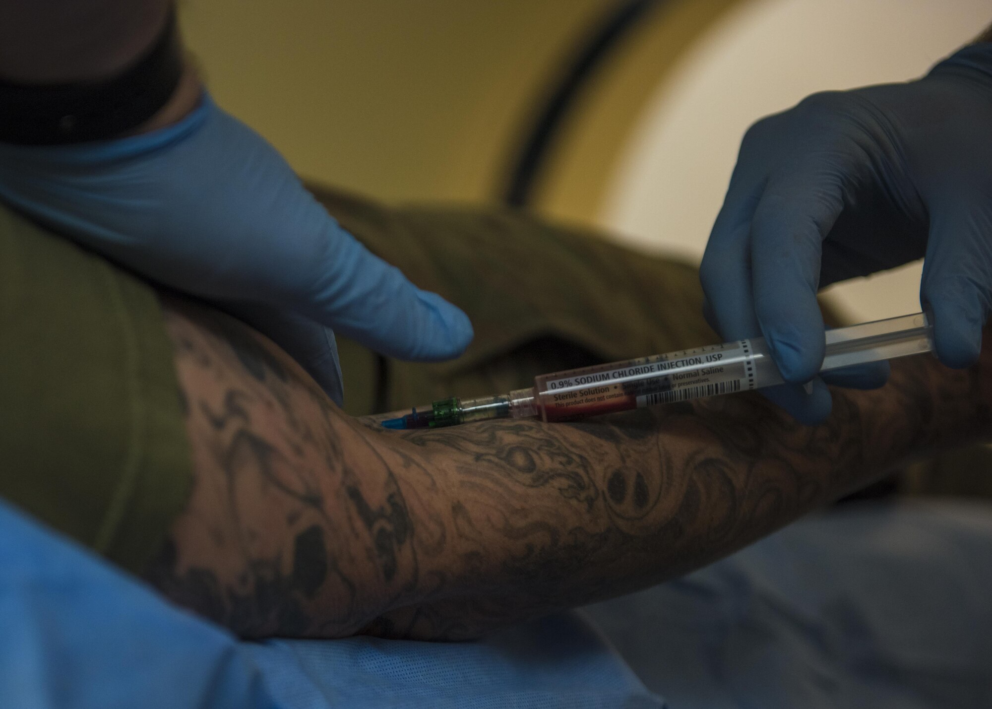 Staff Sgt. Christopher Moore, 455th Expeditionary Medical Group, diagnostic imaging technician, injects an intra venous contrast into a patient, Bagram Airfield, Afghanistan, July 20, 2016. The contrast is used to enhance internal organs and vessels to allow for a better reading of the computed tomography scan. (U.S. Air Force photo by Senior Airman Justyn M. Freeman)