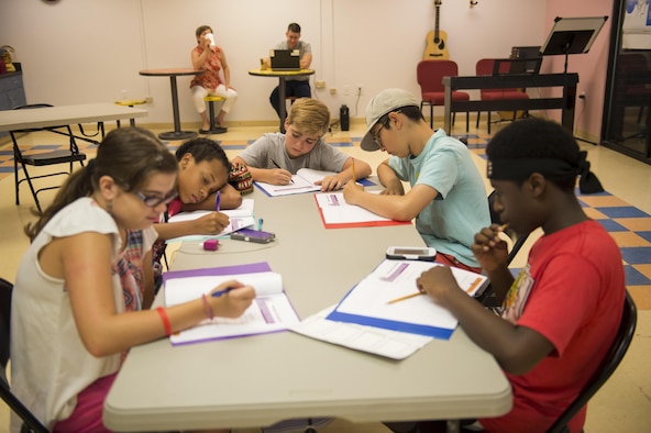 Participants of the first Air Force resiliency teen camp, named BOUNCE, write in their folders July 14, 2016, at Joint Base Charleston, S.C. BOUNCE, which stands for Be optimistic, Observe thoughts, Use strengths, Never give up, Communicate effectively and Embrace you, was a weeklong camp designed to teach teens the necessary skills to overcome daily stressors associated to military families. (U.S. Air Force photo/Staff Sgt. Jared Trimarchi)