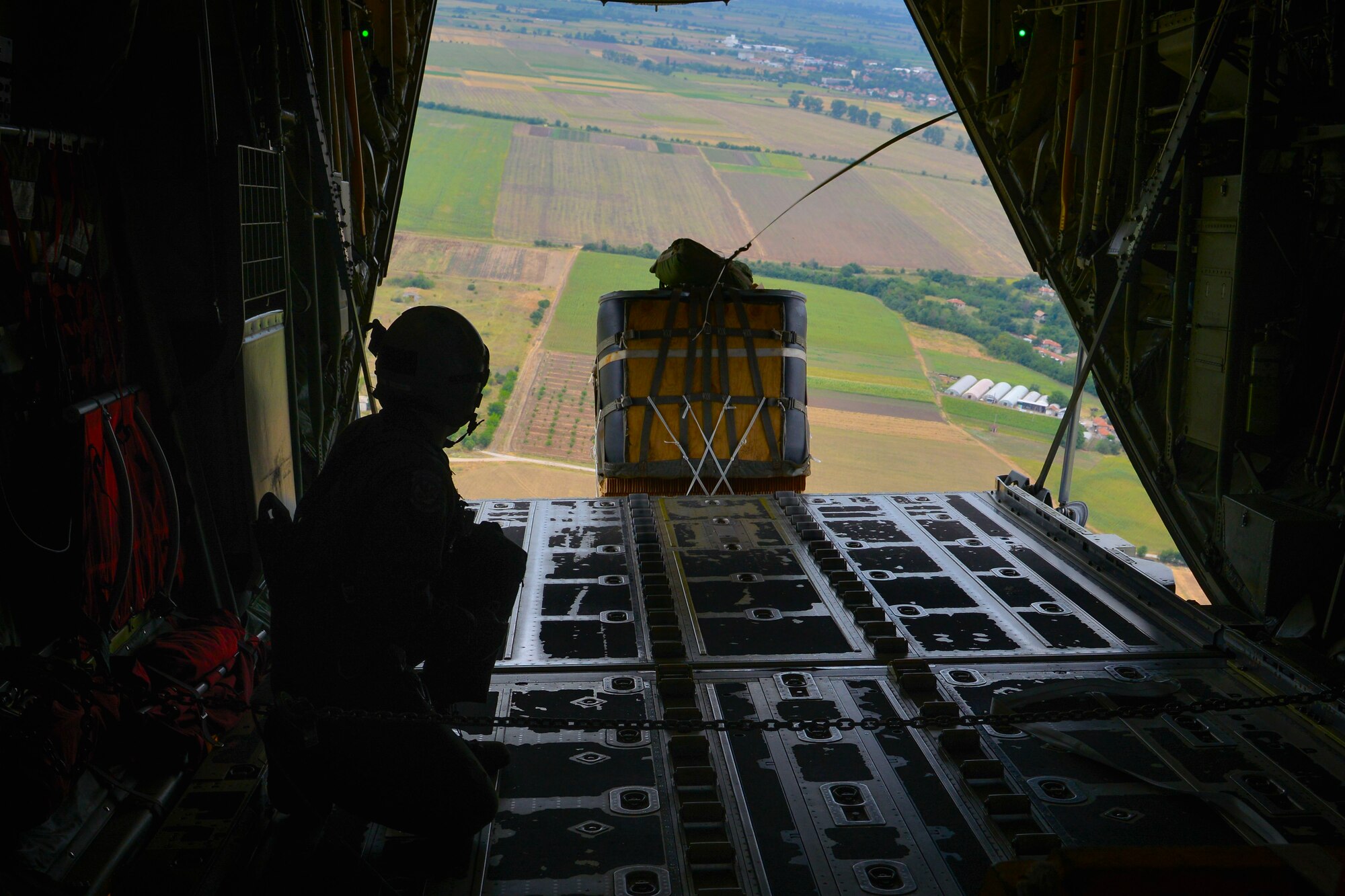 Staff Sgt. Jordan Callahan, 37th Airlift Squadron loadmaster, drops a cargo-delivery system out of a C-130J Super Hercules over Plovdiv, Bulgaria during exercise Thracian Summer 2016, July 20, 2016. Through Exercise Thracian Summer, the United States and Bulgaria will enhance their mutual abilities to work together, with other NATO nations and with key regional partners on regional security, and help prepare Bulgaria for potential future operations in support of contingency operations around the world. The U.S. values the shared commitment and close cooperation with Bulgaria and other NATO allies on countering a range of regional and global threats. (U.S. Air Force photo/Senior Airman Nicole Keim)