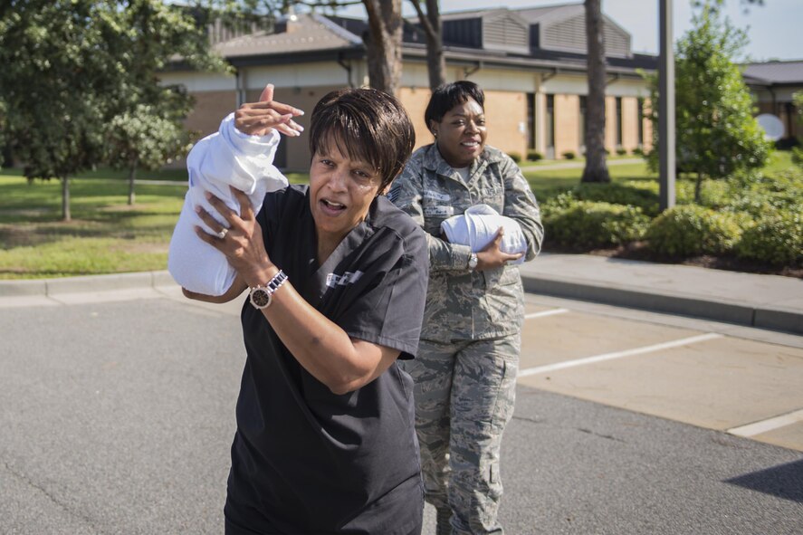 Shelia Davis, 23d Medical Operations Squadron women’s health nurse, and U.S. Air Force Tech. Sgt. Ruth Celestine, 23d Medical Support Squadron NCO in charge of medical evaluation boards and patient travel, evacuate a building while also simulating injuries during an active-shooter exercise, July 20, 2016, at Moody Air Force Base, Ga. The 23d Security Forces Squadron responded and simulated neutralizing the threat and securing the area for simulated injured personnel to evacuate. (U.S. Air Force photo by Airman Daniel Snider)