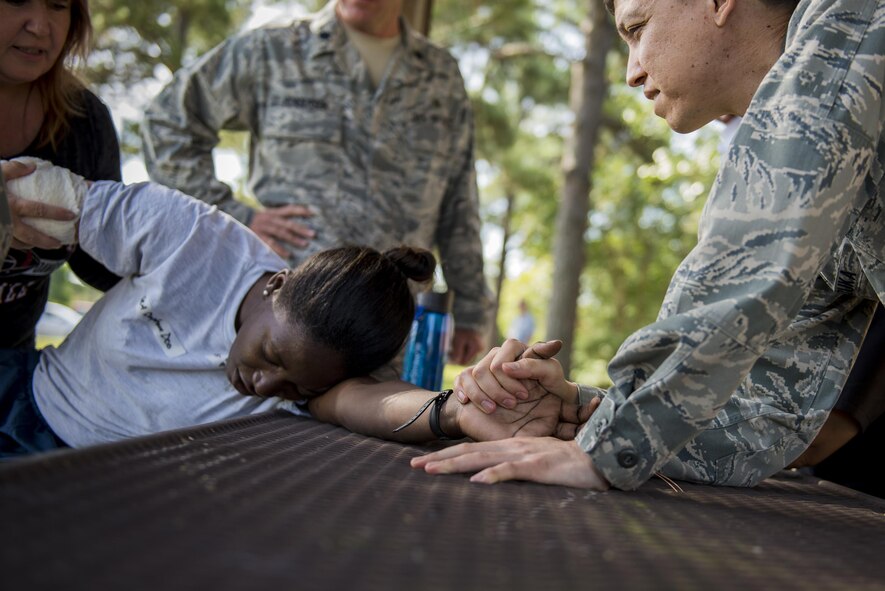 Members of the 23d Medical Group assist U.S. Air Force Senior Airman Dyamond Anderson, 23d Medical Support Squadron diagnostic imaging technician, during an active-shooter exercise, July 20, 2016, at Moody Air Force Base, Ga. Once outside and to a secure area, medical staff assisted the simulated injured Airmen. (U.S. Air Force photo by Airman Daniel Snider)