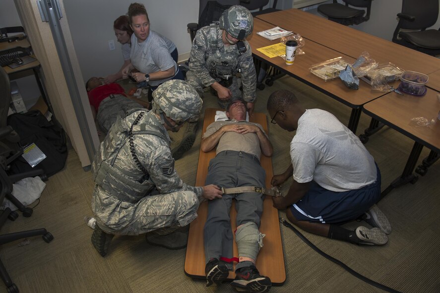 Members of the 23d Medical Group and 23d Security Forces Squadron team up to assist the simulated casualties during an active-shooter exercise, July 20, 2016, at Moody Air Force Base, Ga. Airmen were resourceful and used a tabletop as a gurney for simulated unconscious personnel. (U.S. Air Force photo by Airman Daniel Snider)
