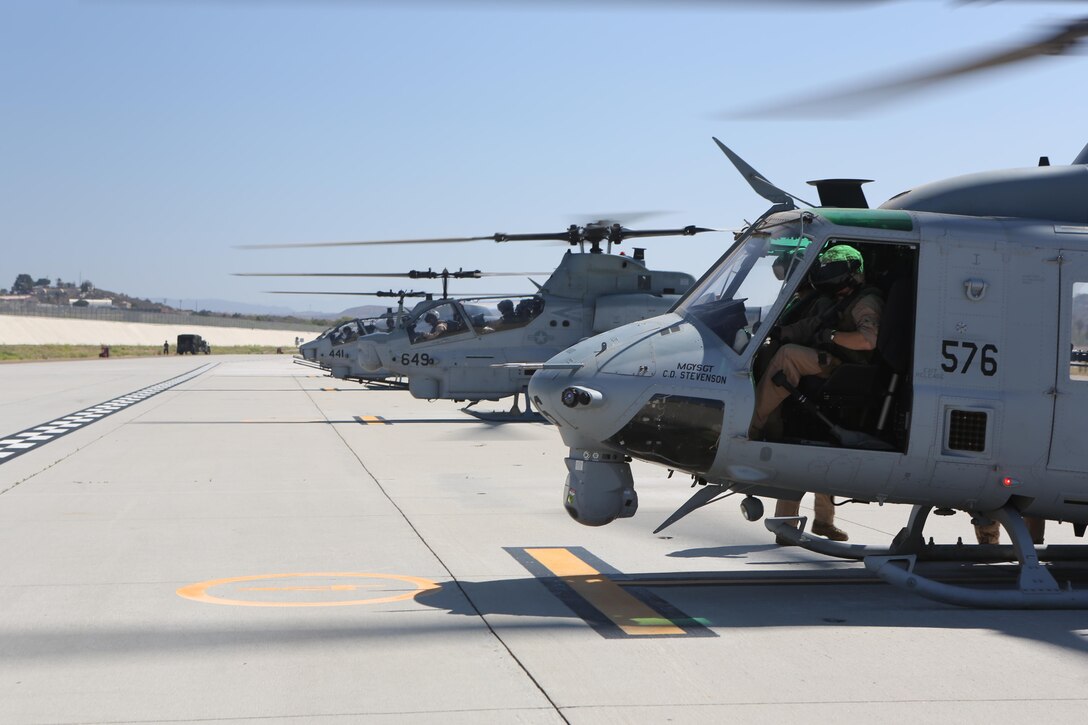 Aircraft with Marine Light Attack Helicopter Squadron (HMLAT) 303, 3rd Marine Aircraft Wing, prepare aircraft prior to performing an aerial demonstration during the family day aboard Marine Corps Air Station Camp Pendleton, Calif., July 16. The squadron held the event to show the service members’ family and friends what they do every day to maintain mission readiness. (U.S. Marine Corps photo by Pfc. Liah Kitchen/Released)