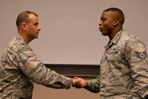 U.S. Air Force Reserve Col. Craig Drescher, commander of the 913th Airlift Group, presents his last challenge coin as Group commander to Staff Sgt. Marquice Combs, for his work as program manager of the Development Training Flight for the 913 AG, at Little Rock Air Force Base, Ark., June 28, 2016. Drescher is leaving the 913 AG to take a position at Air Force Reserve Command Headquarters at Robins Air Force Base, Ga. (U.S. Air Force photo by Master Sgt. Jeff Walston)  
    
